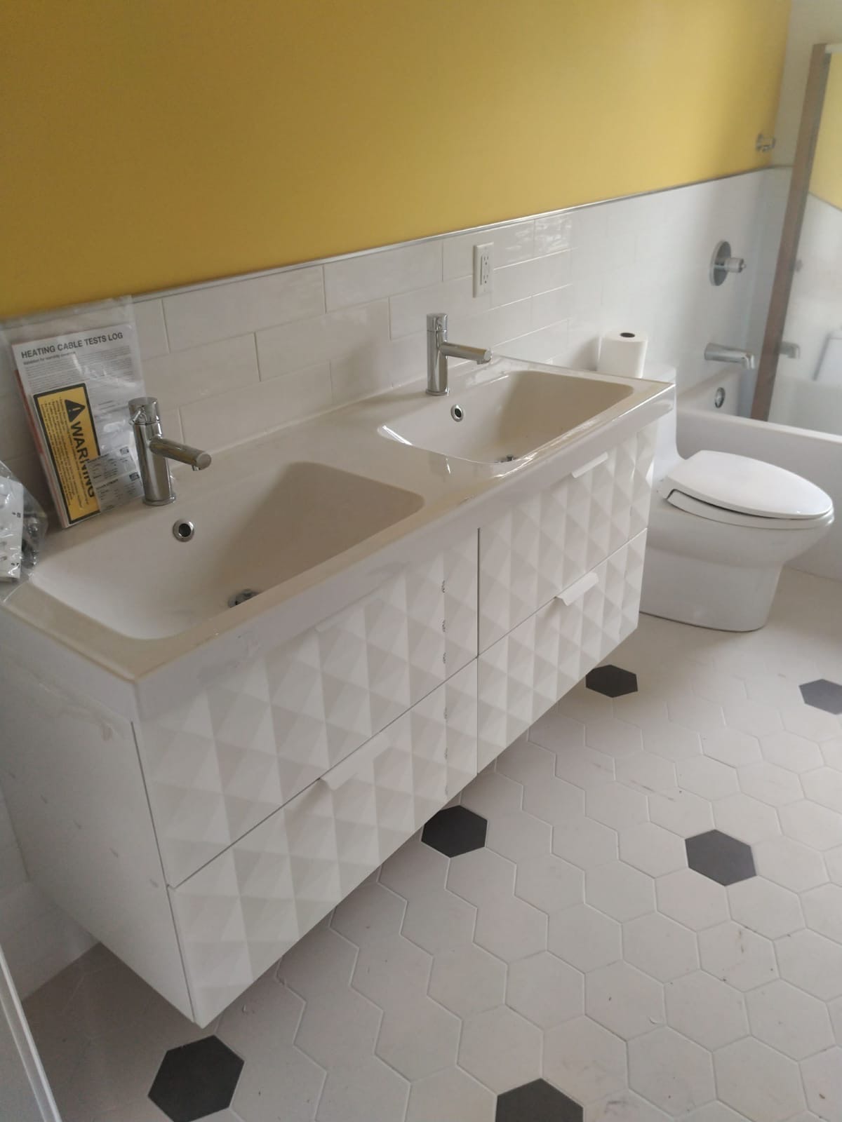 Completed bathroom renovation with white cabinetry